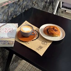 Un libro, un café y una factura en una mesa del café