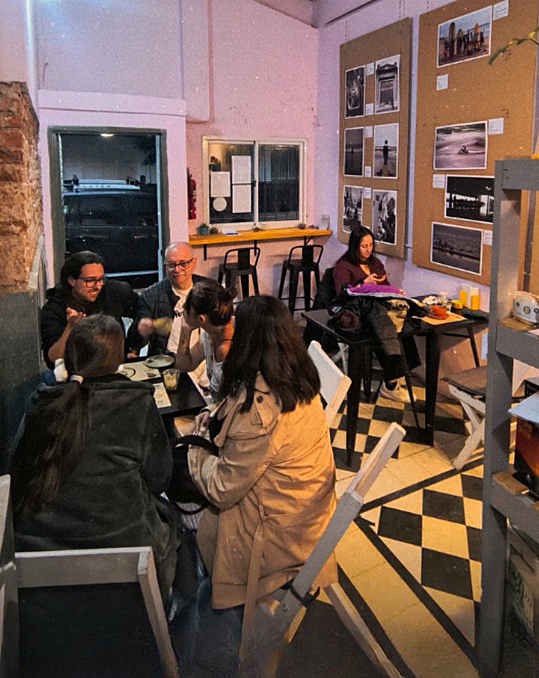 El salón del café: mesas, piso de damero y fotografías del club en las paredes